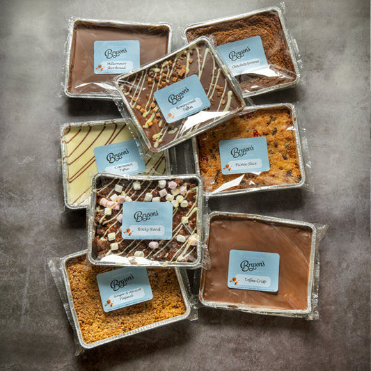 8 flavours of Bryson's traybakes in their packaging on a dark background