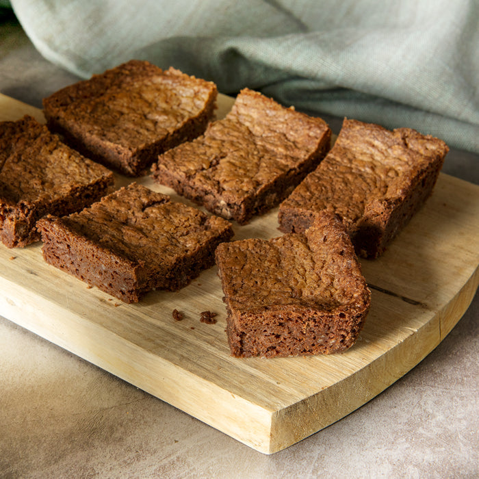 Bryson's Brownie cut into 6 slices on a chopping board.