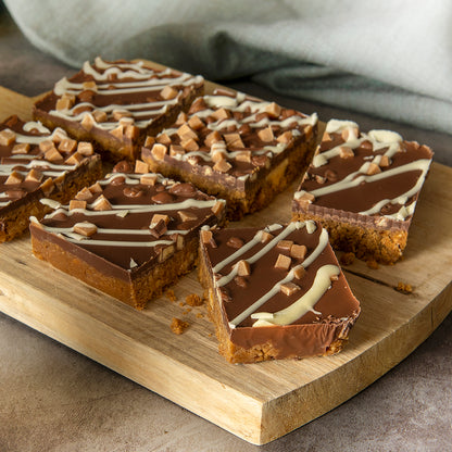 Bryson's Honeycomb Tiffin Slices on a chopping board. Made with honeycomb and caramel fudge pieces.